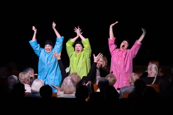 Three figures stand up in the audience. The Seaweed Sisters. Photo by Jingzi Zhao