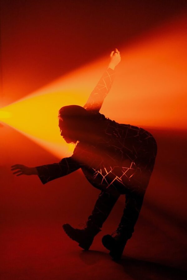 A dancer backlit in orange
