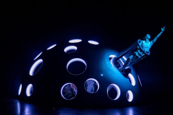 A dancer juts out from large ball structure