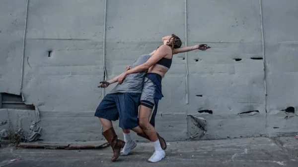 Two dancers against a grey wall