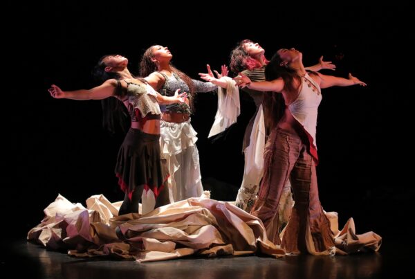 a group of dancers extend their arms and look up