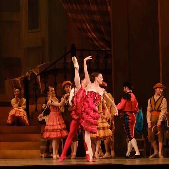 Ballet dancer in red kicks leg