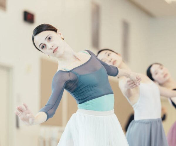 A ballet dancer in blue bends back
