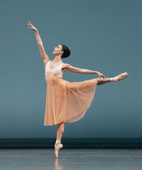 A dancer in apricot in arabesque