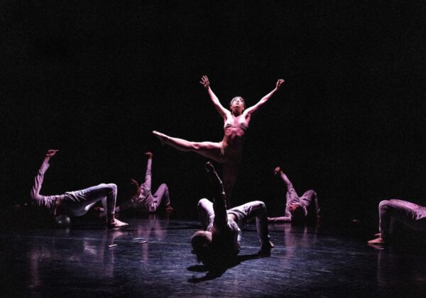 One dancer stands while others are on ground