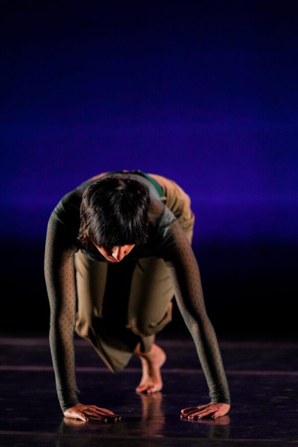 A dancer on her hands and knees