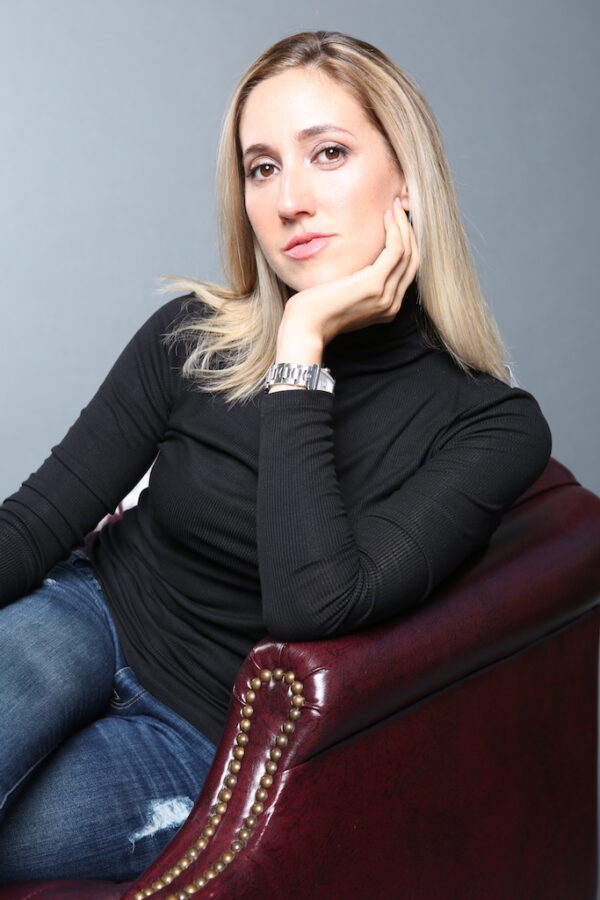 A blond woman looks at camera