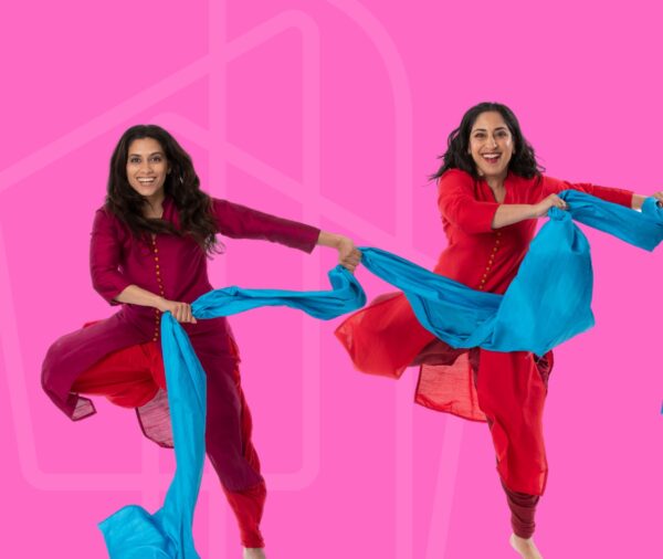 Two dancers in red hold blue scarf