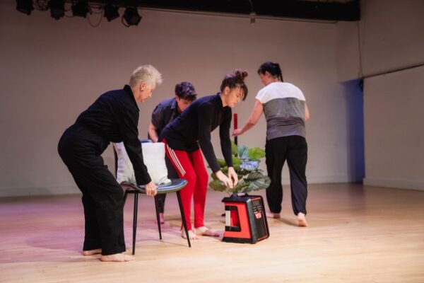 Several dancers move object