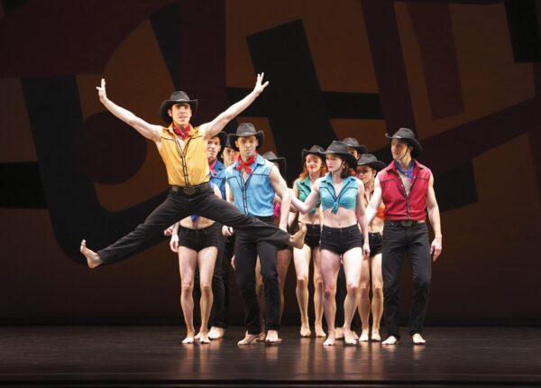 A dancer with cowboy hat jumps