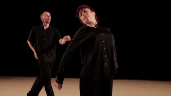 A male dancer moves behind a female dancer