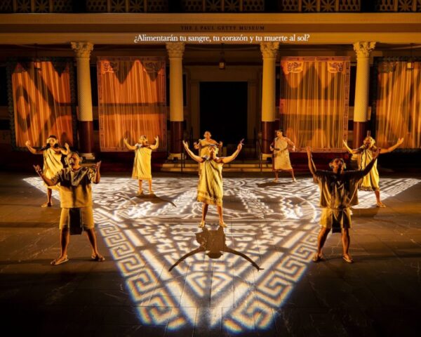 Figures onstage in gold and orange light