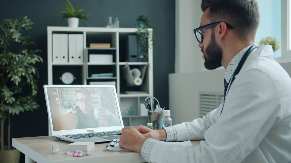 CD-healthcare-virtual-assistant-Insert2 A doctor in a white coat on a laptop video call in an office