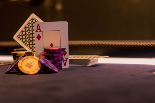 CD-casino-bonus-wagering-Insert1 Ace of diamonds playing card standing among stacked poker chips on a casino table