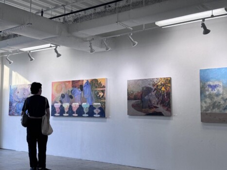 CD-Insert3 Person with a bag standing in a white gallery viewing several large colorful paintings hung on the wall