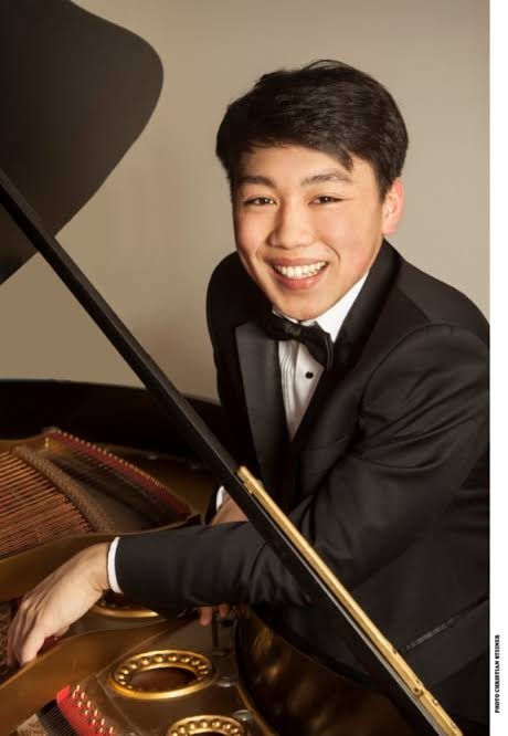 A man at a piano faces camers