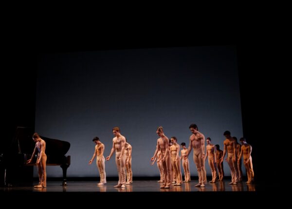 A group of dancers in nude colored costumes