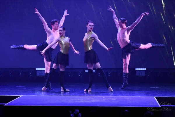 Two female dancers pose while two male dancers jump
