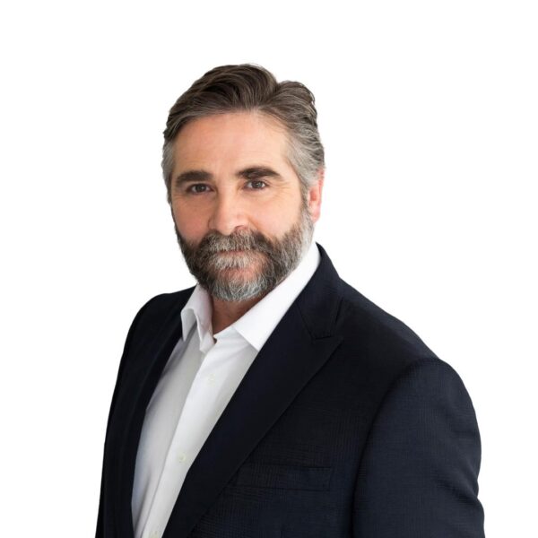 A bearded man faces camera