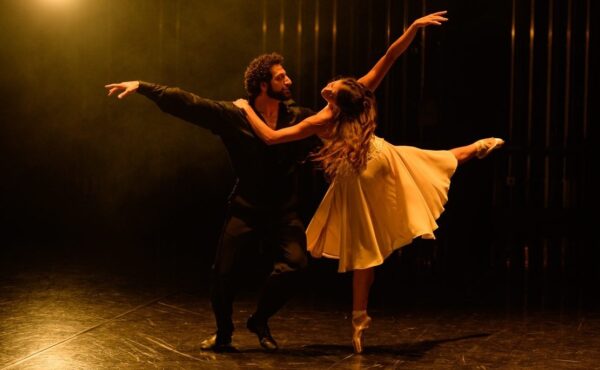 A dancer in black holds a dancer in white