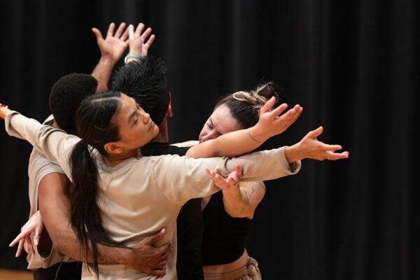Several dancers with arms entwined